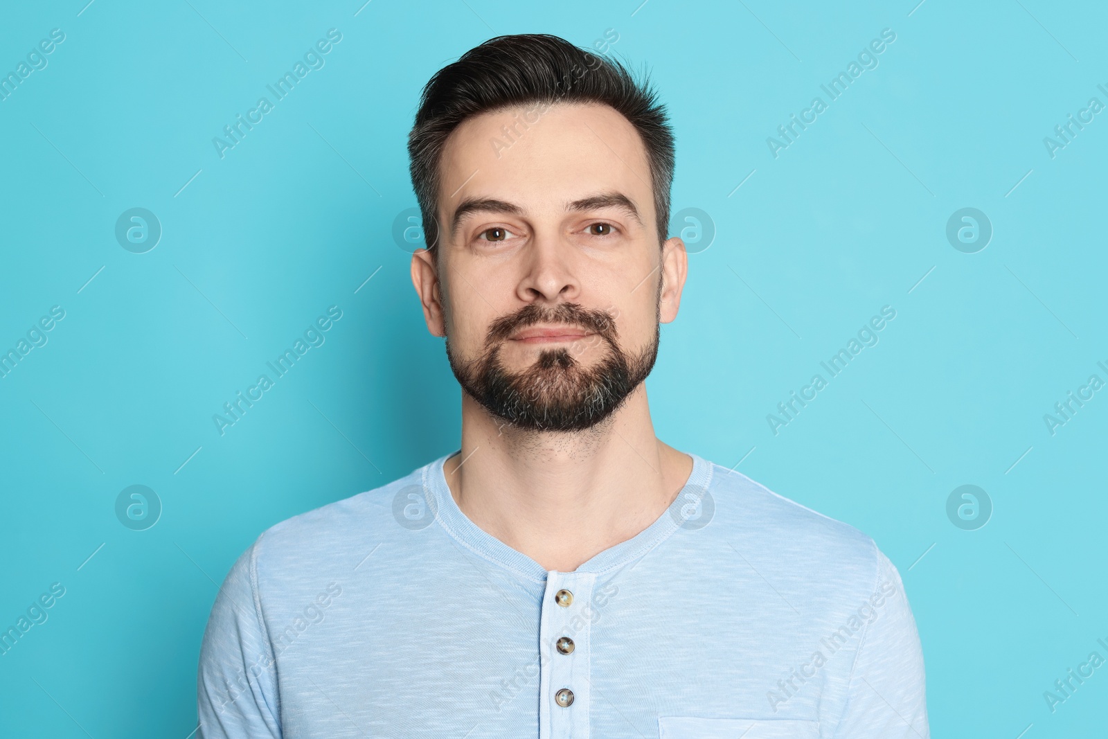 Handsome man before shaving on light blue background Photo of Handsome man before shaving on light blue background