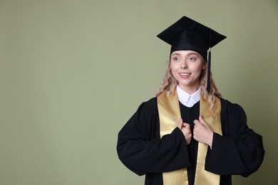 Photo of Happy student after graduation on green background. Space for text
