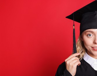 Photo of Happy student after graduation on red background, closeup. Space for text
