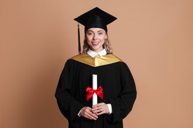 Photo of Happy student with diploma after graduation on beige background