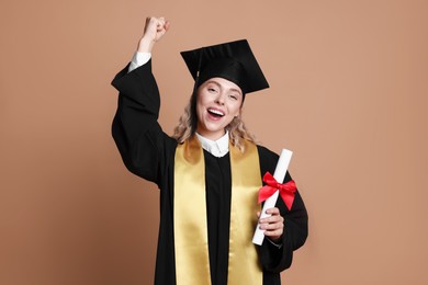 Photo of Happy student with diploma after graduation on beige background