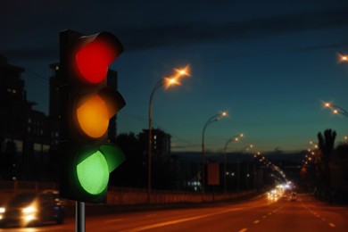 Image of Traffic lights on city road in evening, bokeh effect . Signaling device