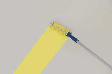 Image of Painting white ceiling with yellow dye indoors, low angle view