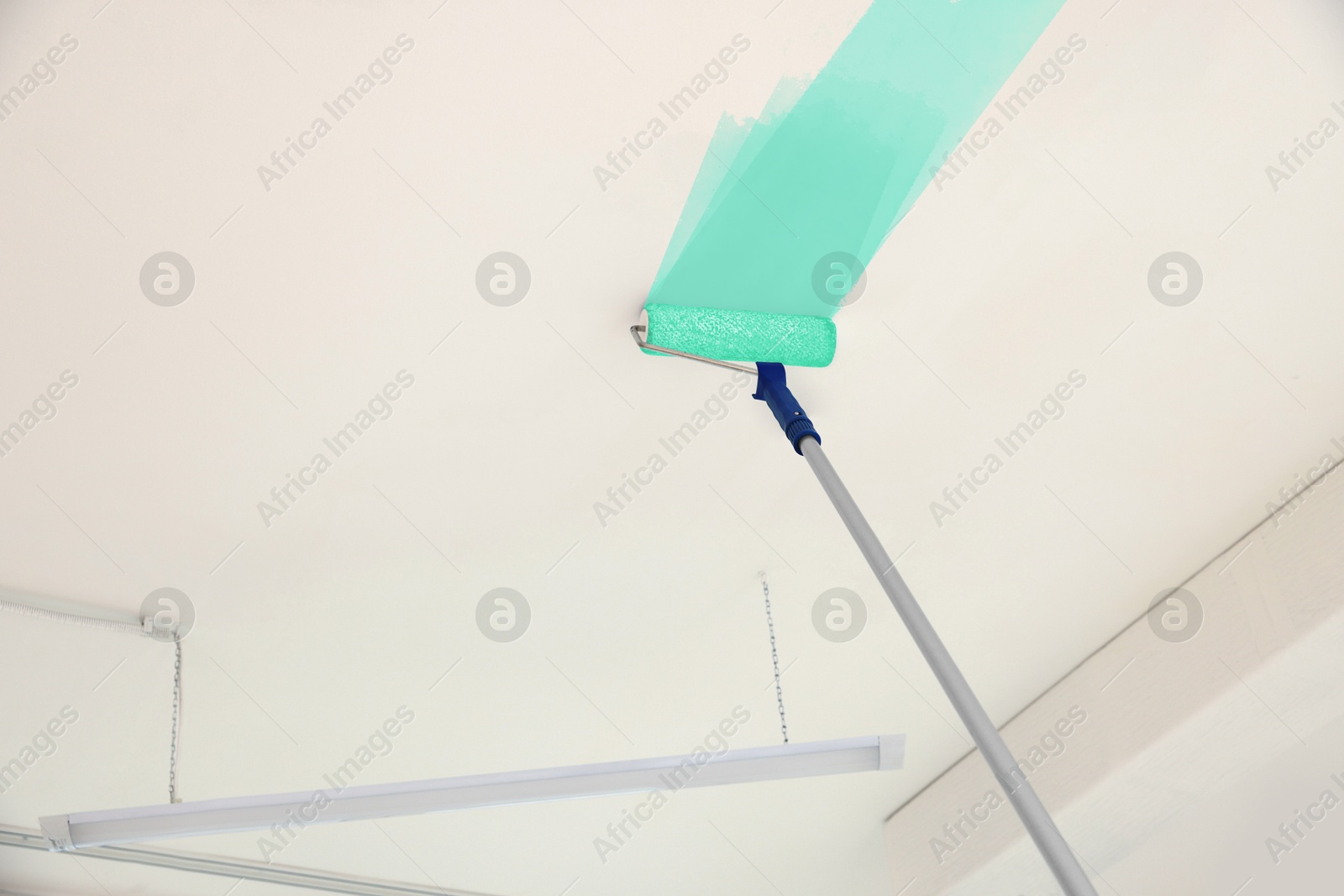 Painting white ceiling with turquoise dye indoors, low angle view Image of Painting white ceiling with turquoise dye indoors, low angle view