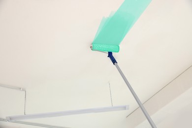 Image of Painting white ceiling with turquoise dye indoors, low angle view