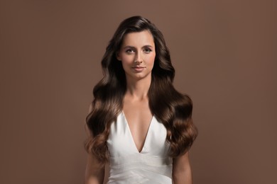 Image of Beautiful woman with shiny healthy hair on pale brown background