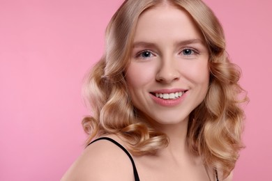 Image of Beautiful young woman with shiny healthy hair on pink background