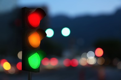 Image of Traffic lights on city street in evening, bokeh effect . Signaling device