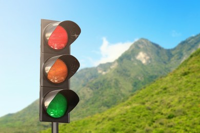 Image of Traffic lights against mountain in countryside. Signaling device