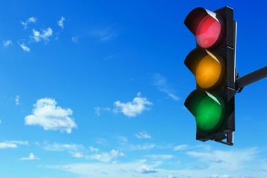 Image of Traffic lights against blue sky with clouds