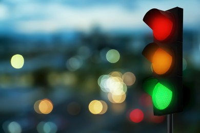 Image of Traffic lights on city street in evening, bokeh effect . Signaling device