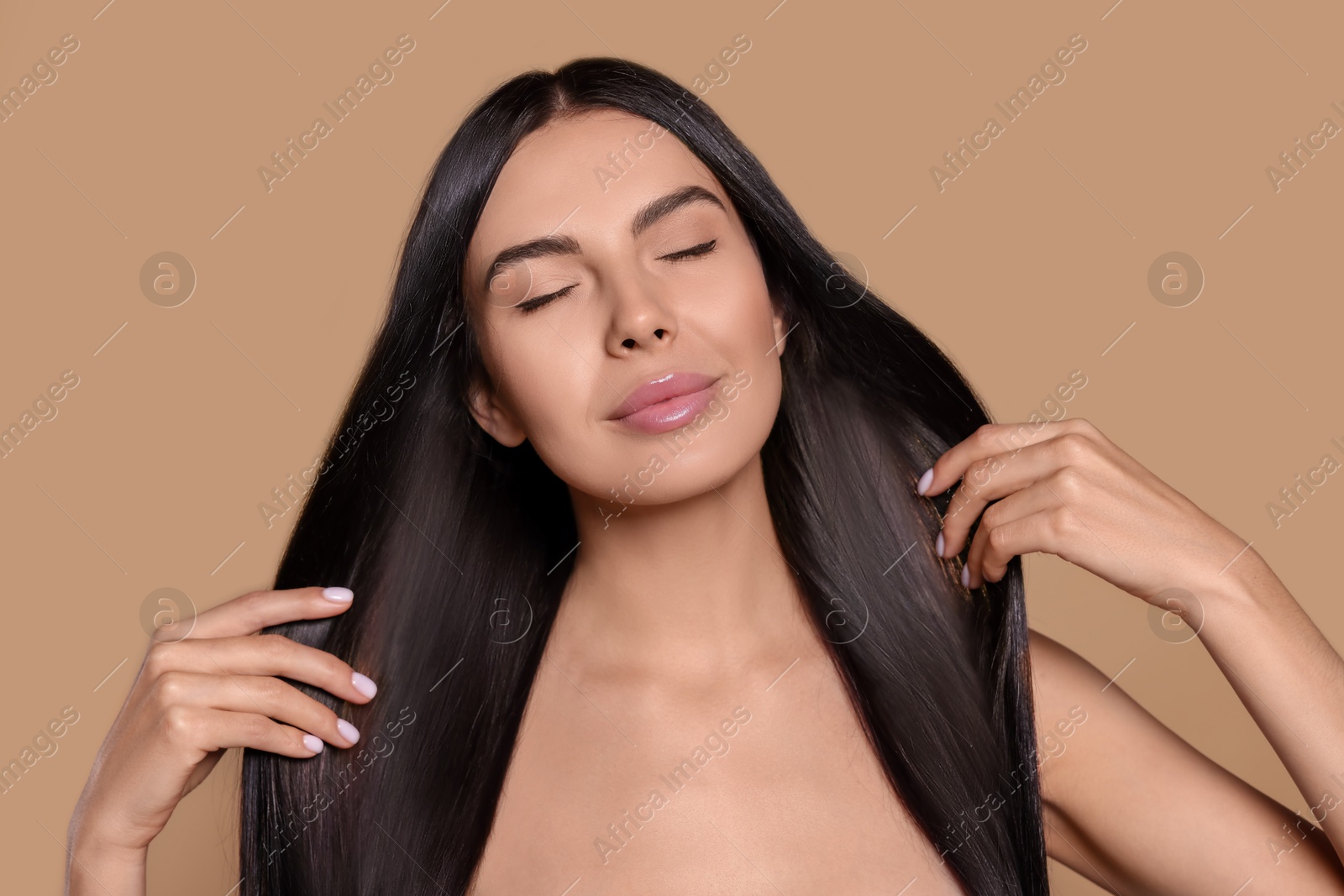Beautiful young woman with shiny healthy hair on dark beige background Image of Beautiful young woman with shiny healthy hair on dark beige background