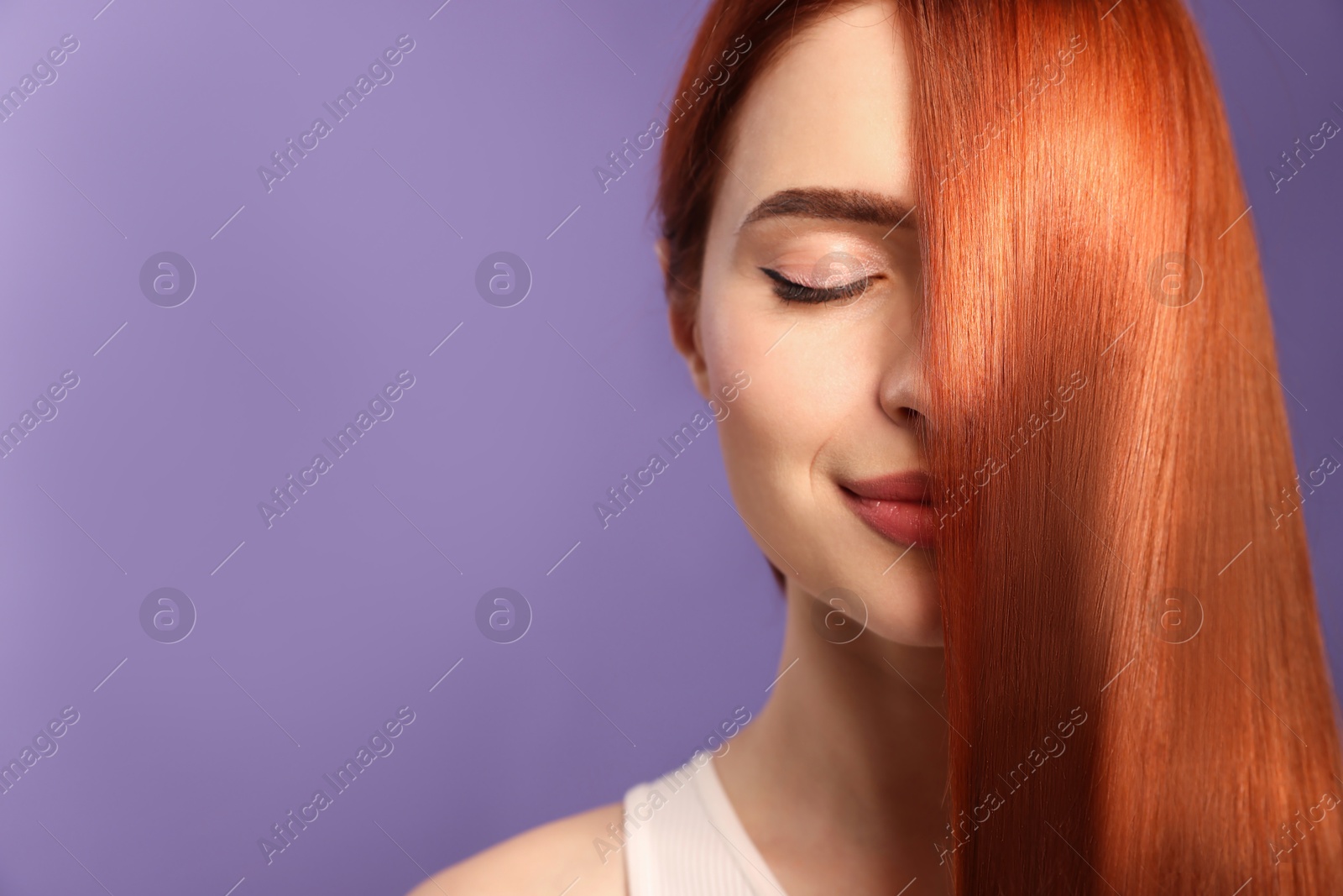 Beautiful young woman with shiny healthy red hair on violet background Image of Beautiful young woman with shiny healthy red hair on violet background