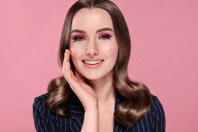 Image of Beautiful young woman with shiny healthy hair on pink background