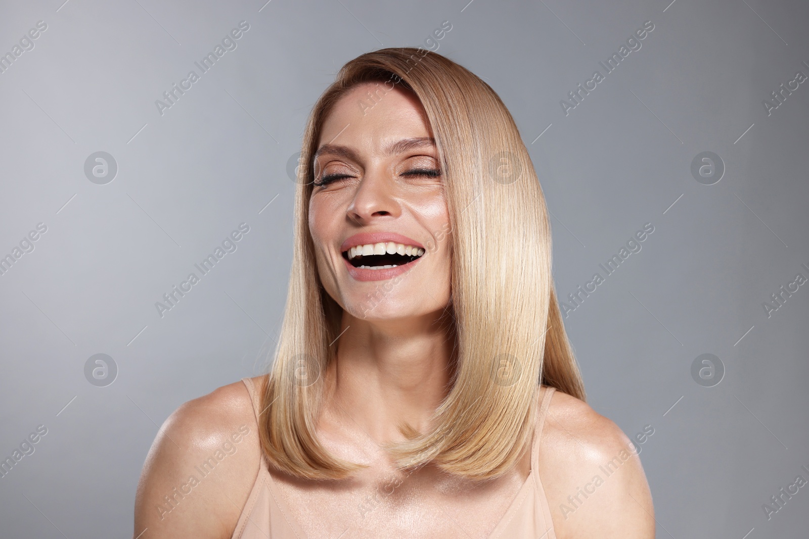 Beautiful woman with shiny healthy hair on grey background Image of Beautiful woman with shiny healthy hair on grey background