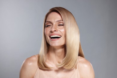 Image of Beautiful woman with shiny healthy hair on grey background