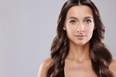 Image of Beautiful woman with shiny healthy hair on grey background