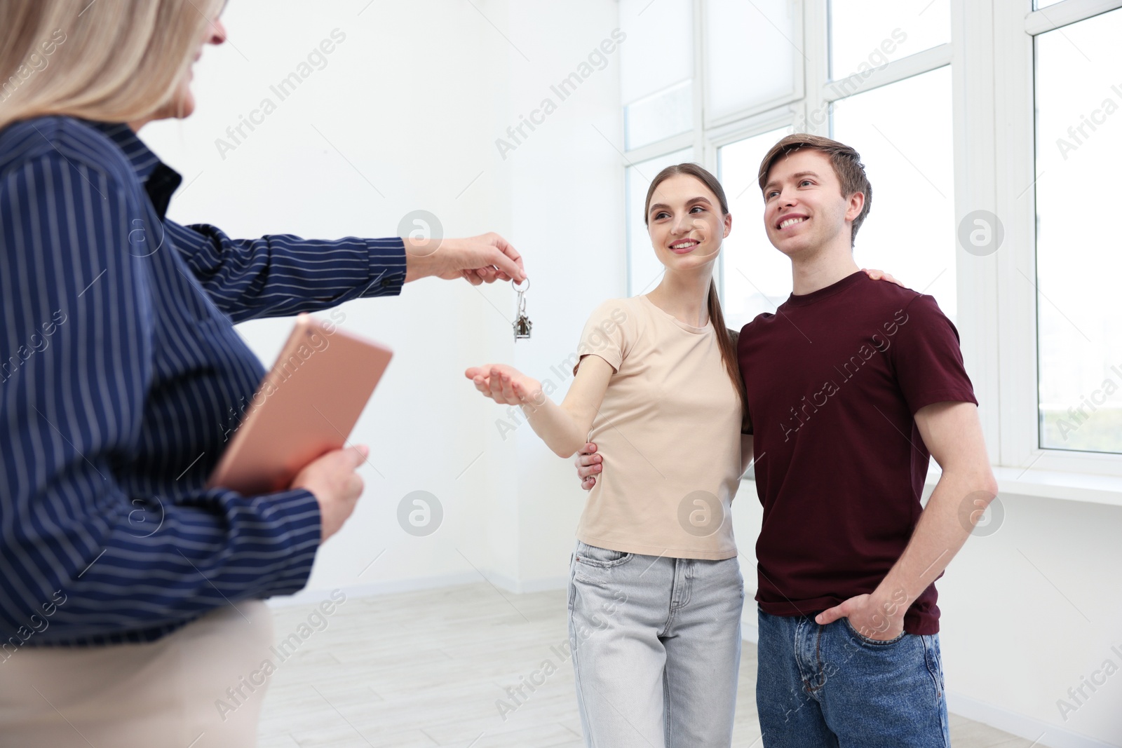 Real estate agent with tablet giving house key to new owner at home, closeup Photo of Real estate agent with tablet giving house key to new owner at home, closeup