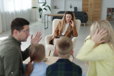 Photo of Family having consultation with psychologist in office, selective focus