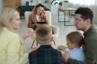 Photo of Family having consultation with psychologist in office, selective focus