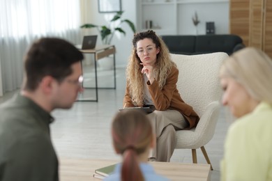 Photo of Family having consultation with psychologist in office, selective focus