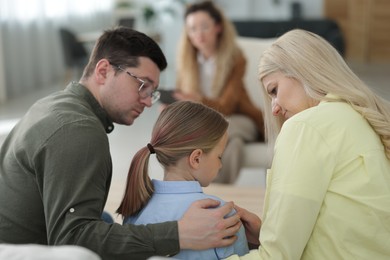 Photo of Family having consultation with psychologist in office, selective focus