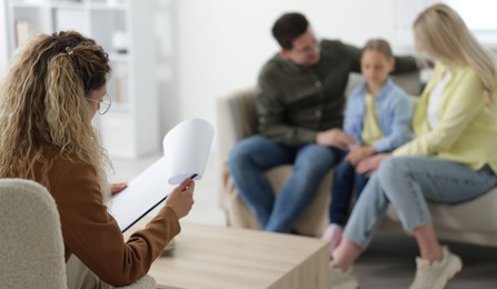 Photo of Family having consultation with psychologist in office, selective focus