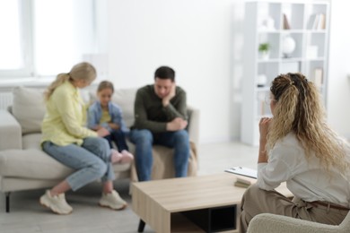 Photo of Family having consultation with psychologist in office, selective focus
