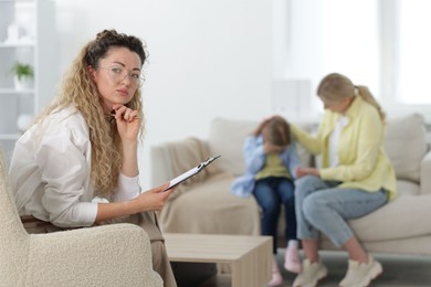 Photo of Mother and daughter having consultation with psychologist in office, selective focus