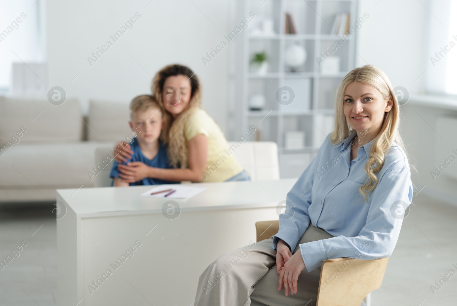 Mother and son having consultation with smiling psychologist in office, selective focus Photo of Mother and son having consultation with smiling psychologist in office, selective focus