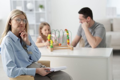 Photo of Father and daughter having consultation with psychologist in office, selective focus