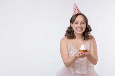 Photo of Birthday celebration. Woman with cupcake on white background. Space for text