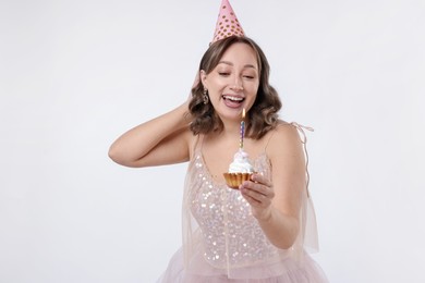 Photo of Birthday celebration. Woman with cupcake on white background
