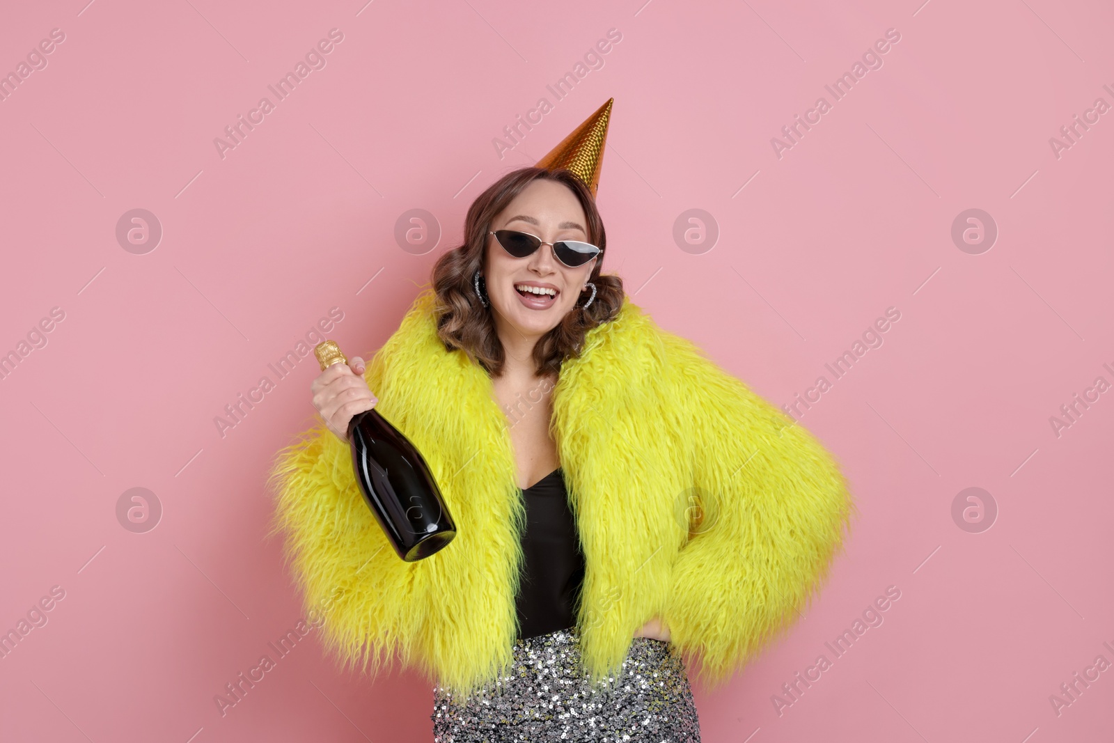 Birthday celebration. Woman with sparkling wine on pink background Photo of Birthday celebration. Woman with sparkling wine on pink background