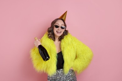 Photo of Birthday celebration. Woman with sparkling wine on pink background