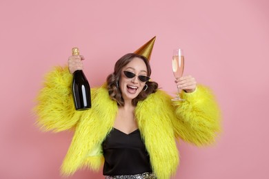 Photo of Birthday celebration. Woman with sparkling wine on pink background