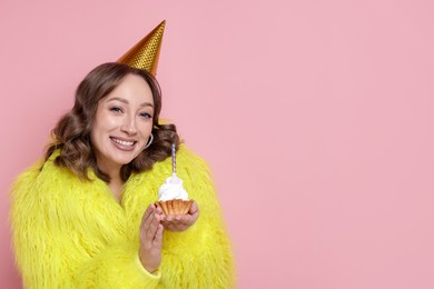 Photo of Birthday celebration. Woman with cupcake on pink background. Space for text