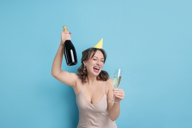 Photo of Birthday celebration. Woman with sparkling wine on light blue background