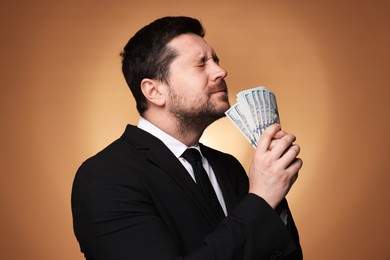 Photo of Greedy banker with dollar banknotes on golden background