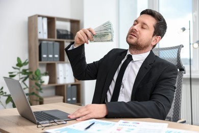 Photo of Greedy banker waving money at table in office
