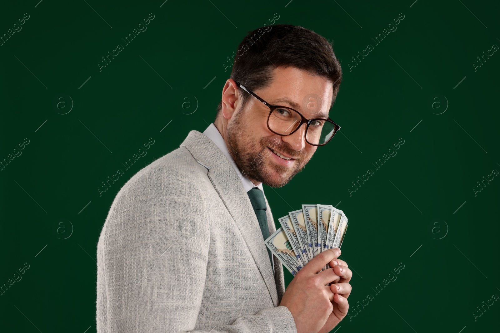 Happy greedy banker with dollar banknotes on green background Photo of Happy greedy banker with dollar banknotes on green background