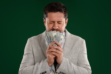 Photo of Greedy banker with dollar banknotes on green background