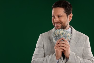 Photo of Happy greedy banker with dollar banknotes on green background. Space for text