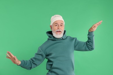 Photo of Elderly man in stylish outfit on green background