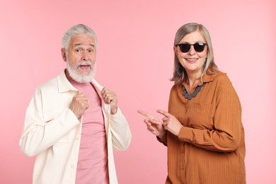 Photo of Senior couple in stylish outfits on pink background