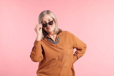 Photo of Senior woman in stylish outfit on pink background