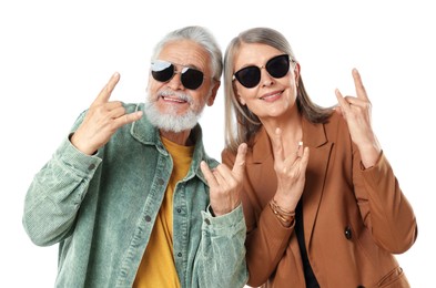 Photo of Senior couple in stylish outfits making rock gestures on white background