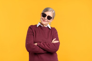Photo of Happy senior woman in stylish outfit on orange background