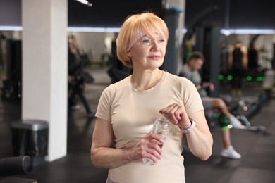 Photo of Senior woman with bottle of water in gym