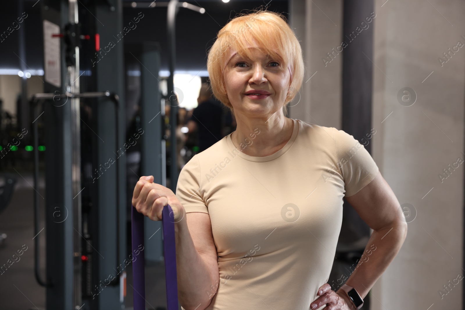 Senior woman doing exercise with fitness elastic band in gym Photo of Senior woman doing exercise with fitness elastic band in gym